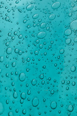 The texture of blue glass with air bubbles inside. A close-up.