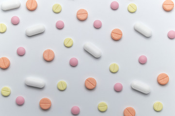 Different colorful drugs or medicine pills tablet supplements for the treatment and health care on a white background.