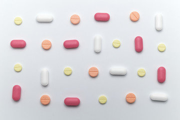 Different colorful drugs or medicine pills tablet supplements for the treatment and health care on a white background.