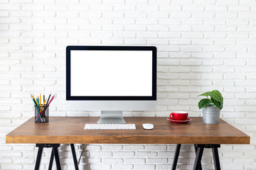 Mockup blank screen computer on a wooden desk. desktop empty white screen, with workspace and office supplies on table