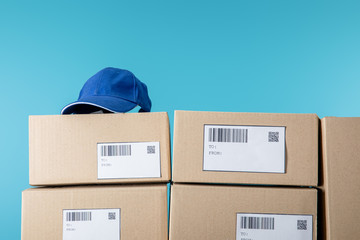 Cap on cardboard boxes with qr and barecodes isolated on blue