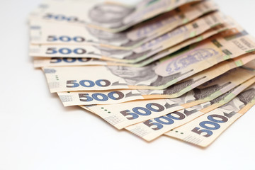 A lot of new banknotes in denominations of 500 Ukrainian hryvnias isolated on a white background with shadow. European money exchange. Ukraine currency. Selective focus