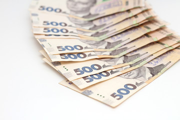 A lot of new banknotes in denominations of 500 Ukrainian hryvnias isolated on a white background with shadow. European money exchange. Ukraine currency. Selective focus