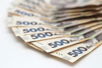 A lot of new banknotes in denominations of 500 Ukrainian hryvnias isolated on a white background with shadow. European money exchange. Ukraine currency. Selective focus