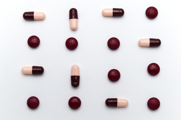 Different colorful medicine pills and .capsules or supplements for the treatment and health care on a white background.