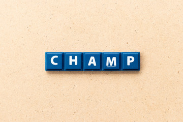 Tile letter in word champ on wood background