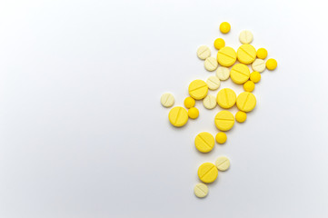 Prescription drugs or medicine pills and tablets of yellow colors shades. On white background. Top view.