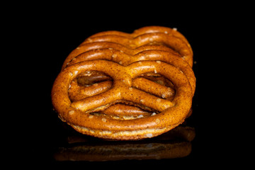 Fototapeta premium Group of five whole salty brown pretzel isolated on black glass