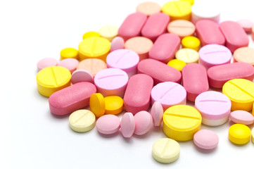 Prescription drugs, pills, capsules and tablets of different colors all mixed in. On white background. Selective focus.