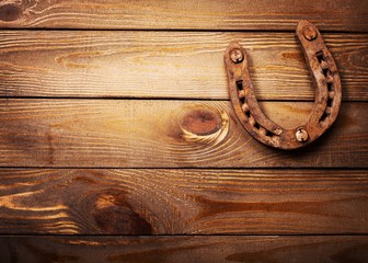 Classic rusty metal horseshoe on wooden table