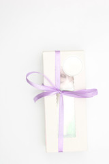 White cardboard box with a transparent top tied with a lilac ribbon isolated on a white background. A wonderful gift for Valentine's Day, birthday.