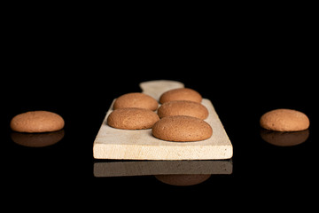 Group of seven whole sweet brown chocolate sponge biscuit on small wooden cutting board isolated on...