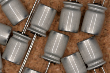 Electronic components, Metallic color electrolytic capacitor (Cork board textured background)
