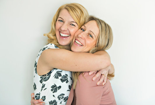 Studio shot of two happy girlfriends over white background
