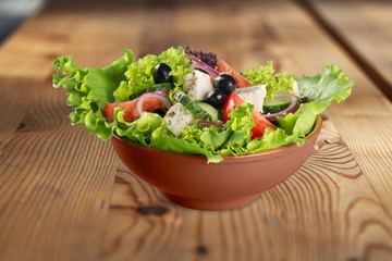 Fresh vegetable salad in a bowl on wooden desk