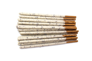 Chocolate biscuit stick coated with milk flavour confectionery and crushed cookies and cream taste isolated on white background.