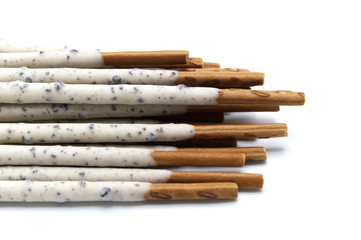 Chocolate biscuit stick coated with milk flavour confectionery and crushed cookies and cream taste isolated on white background.