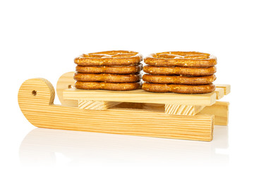 Group of eight whole salty brown pretzel with wooden sledge isolated on white background