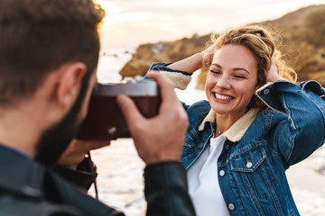 Cheerful pretty young woman posing infront of her boyfriend