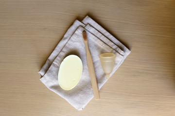 Linen cloth, soap, bamboo toothbrush and menstrual cup. Zero waste bathroom products. Top view.