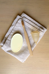 Linen cloth, soap, bamboo toothbrush and menstrual cup. Zero waste bathroom products. Top view.