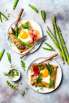 Buckwheat crepes, galette bretonne with asparagus, egg, green pea, jambon or prosciutto. Galette sarrasin, french brittany cuisine