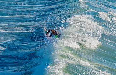 Surfers on the wooden pier of Pismo Beach in California