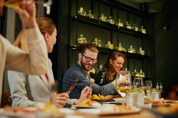 Group of best friends sitting in restaurant, having dinner, drinking wine and having fun.
