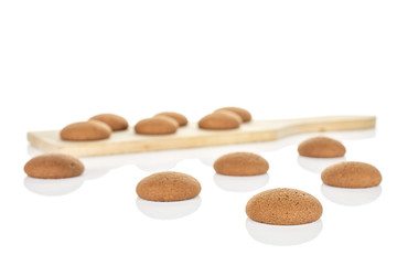 Lot of whole sweet brown chocolate sponge biscuit on small wooden cutting board isolated on white background