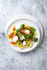 Italian pasta mafalde with green peas, prosciutto, burrata,  and spinach