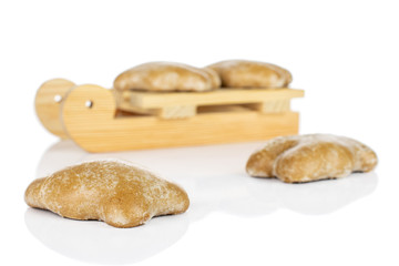 Group of four whole sweet brown gingerbread with wooden sledge isolated on white background