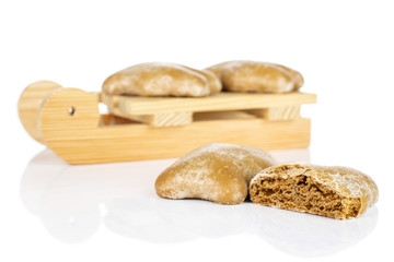 Group of three whole one half of sweet brown gingerbread with wooden sledge isolated on white background