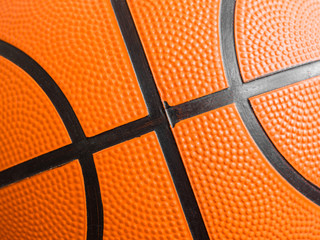 Orange basketball ball close up. Fragment, black stripes, texture. Sport geometric background