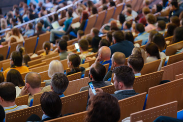 Business conference attendees sit and listen