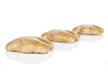Group of three whole sweet brown gingerbread placed diagonally isolated on white background