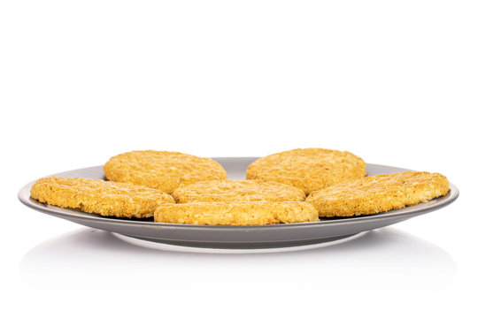 Group Of Six Whole Sweet Golden Oat Cookie On Gray Ceramic Plate Isolated On White Background