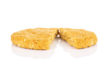 Group of two halves of sweet golden oat cookie isolated on white background