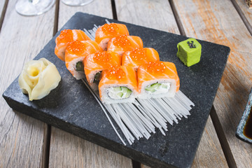 Traditional rolls with fish and rice on a white plate with sauce and wasabi. Japanese food.