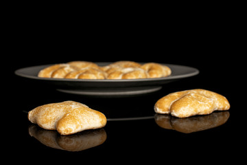 Group of nine whole sweet brown gingerbread on gray ceramic plate isolated on black glass
