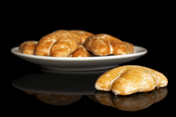 Group of six whole sweet brown gingerbread on white ceramic plate isolated on black glass