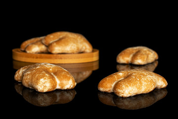 Group of five whole sweet brown gingerbread on bamboo coaster isolated on black glass