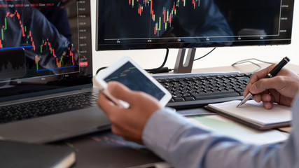 Businessman broker Analyzing finance data graphs and reports on screen for investment purposes for...