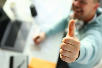 A young designer holds pen from tablet in hand working on new project for customer in field of...