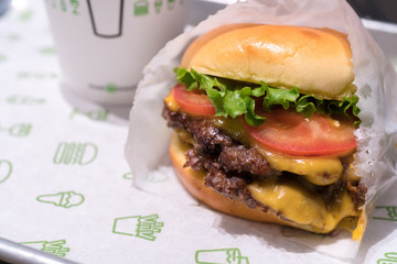 Tokyo Japan - March 27, 2019: Shake Shack Hamburger in Tokyo. Double cheeseburger with tomato lettuce and onion, Cheese Fries and Milkshake.