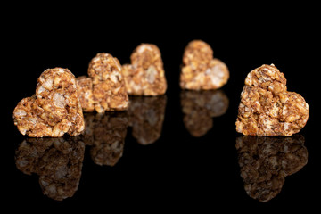 Group of five whole healthy brown cereal heart with cocoa isolated on black glass
