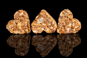 Group of three whole healthy brown cereal heart with cocoa isolated on black glass