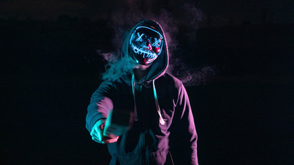 Chico con una máscara de luces con humo y un bate