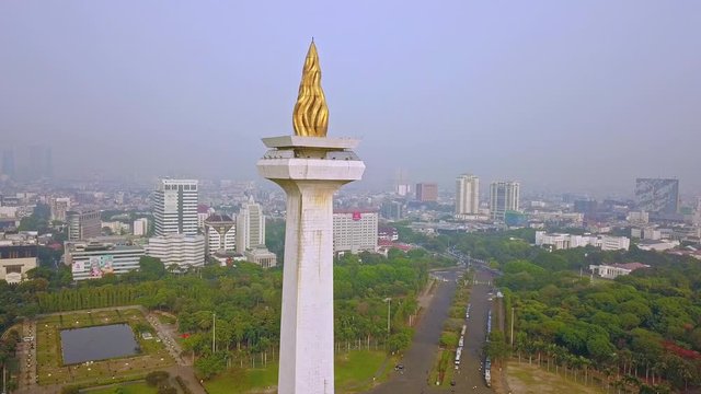 JAKARTA, Indonesia - 08 Juni 2019: Pemandangan udara dari Monumen Nasional Jakarta dengan kabut polusi udara. Ditembak dalam resolusi 4k dari drone