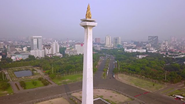 JAKARTA, Indonesia - 08 Juni 2019: Pemandangan udara dari Monumen Nasional Jakarta dengan kabut polusi udara. Ditembak dalam resolusi 4k dari drone