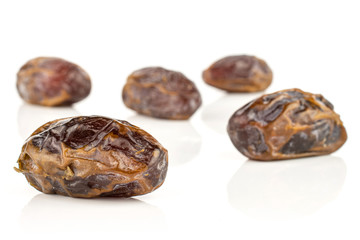 Group of five whole dry brown date fruit isolated on white background